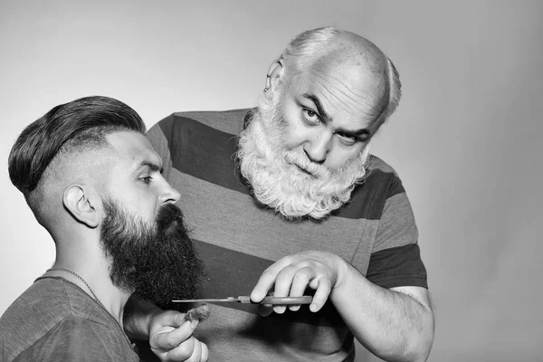 Cabeleireiro velho e homem barbudo jovem — Fotografia de Stock