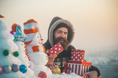 Karlı manzara üzerinde hediye kutuları ile mutlu adam
