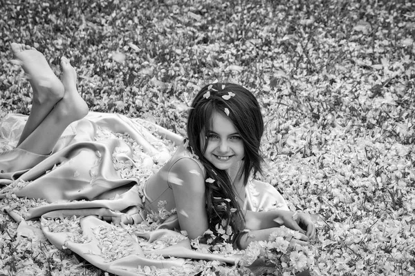Yaprakları yeşil çimenlerin üzerinde küçük kız — Stok fotoğraf