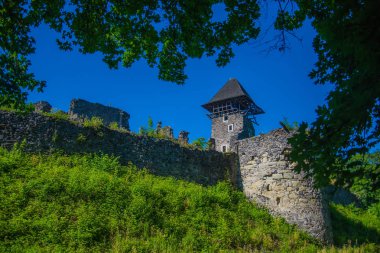 Mavi gökyüzü üzerinde yeşil tepe üzerinde taş sur