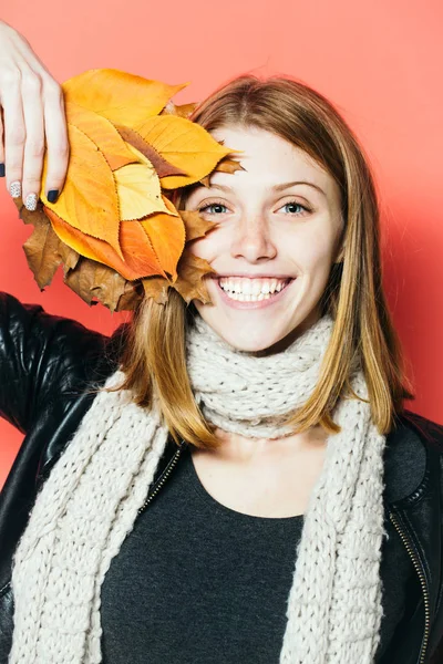 Fille avec des feuilles orange sur fond orange . — Photo