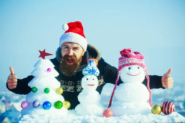 Weihnachtsmann reicht Hände mit schneebedeckten Skulpturen — Stockfoto