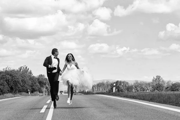 Matrimonio felice coppia in esecuzione su strada — Foto Stock