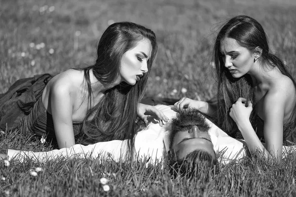 Homem barbudo e duas mulheres na grama — Fotografia de Stock