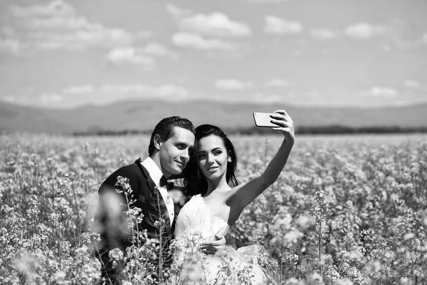 Para ślub w pola żółte kwiaty — Zdjęcie stockowe