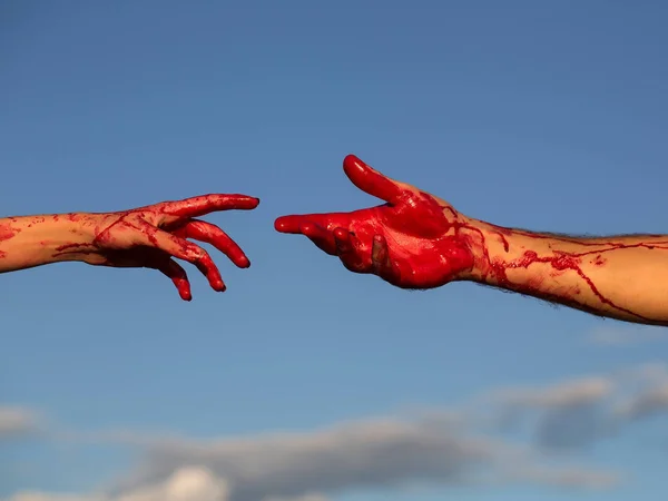 Blodiga zombie händer med rött blod på blå himmel — Stockfoto