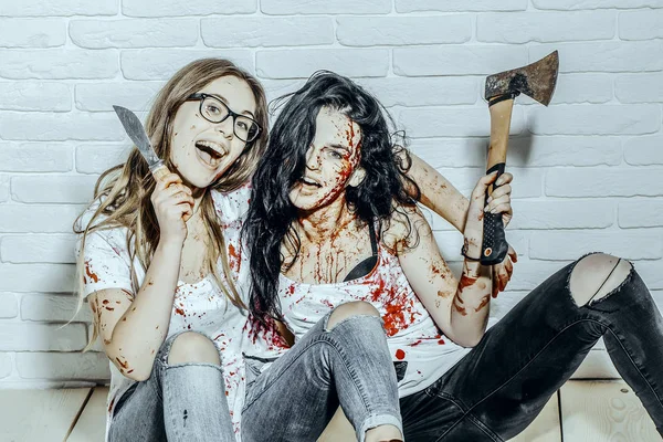 Halloween dívky sedící na podlaze se sekerou a nožem — Stock fotografie