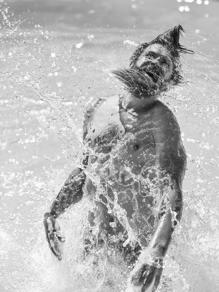 Jeune homme éclaboussant l'eau — Photo