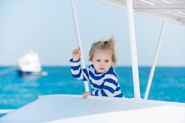 Mavi okyanus su almak çizgili gömlekli çocuk.