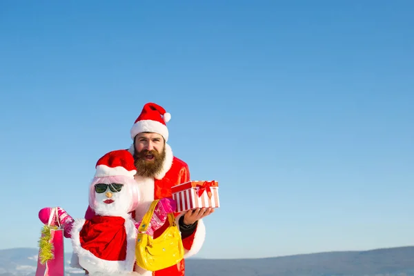 Щасливий Санта-хіпстер тримає подарункову коробку на блакитному небі — стокове фото