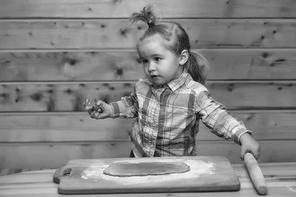 Niedliches Kind, das mit Teig und Mehl kocht, hält metallische Form — Stockfoto