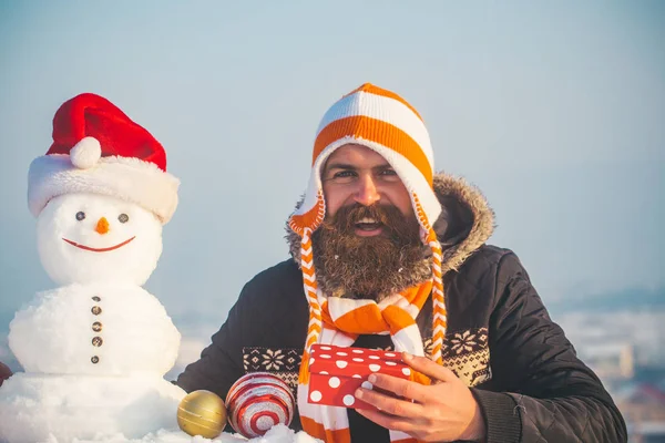 Hipster in cappello sorridente con pupazzo di neve in cappello di Babbo Natale — Foto Stock