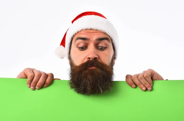 Bärtiger Weihnachtsmann mit grünem Papier auf weißem Hintergrund überrascht — Stockfoto