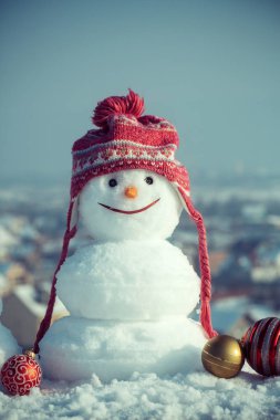 Mavi gökyüzü arka plan üzerinde kırmızı şapkalı kardan adam