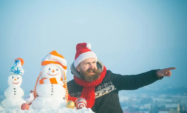 Santa man wijzende vinger met besneeuwde sculpturen — Stockfoto