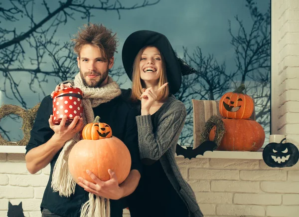 Halloween macho in scarf holding pumpkins