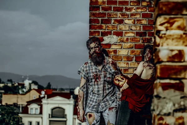Halloween pareja zombie en ropa rasgada de pie en el techo — Foto de Stock