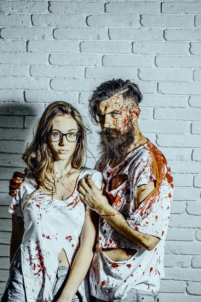 Хэллоуин мужчина обнимает женщину в очках на стене из белого кирпича — стоковое фото