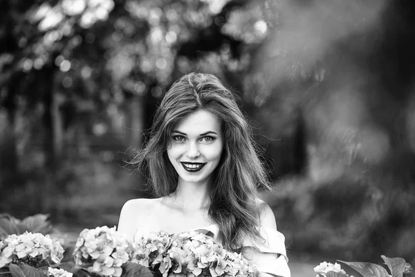 Jolie fille souriante en fleurs d'hortensia — Photo