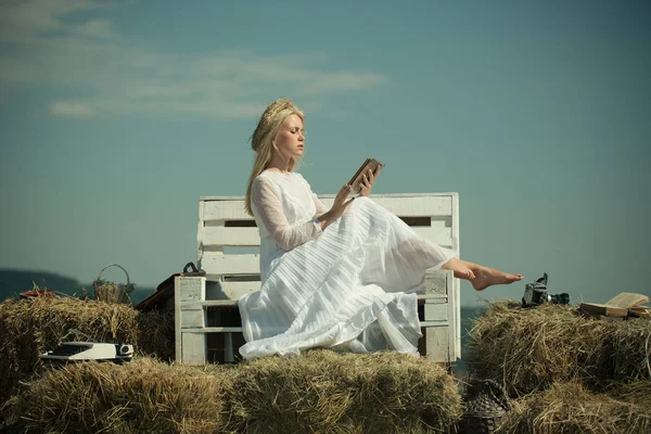 Student with camera and typewriter on hay