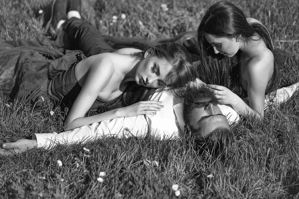 Homem barbudo e duas mulheres na grama — Fotografia de Stock