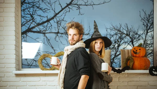 Halloween macho és a lány boszorkány kalap holding kupa — Stock Fotó