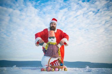 Adam Noel Baba şapkası karlı heykel ile elele