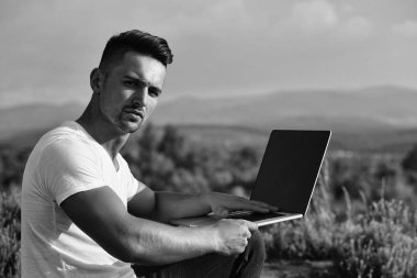 Dizüstü bilgisayar açık ile dalgın kaslı adam