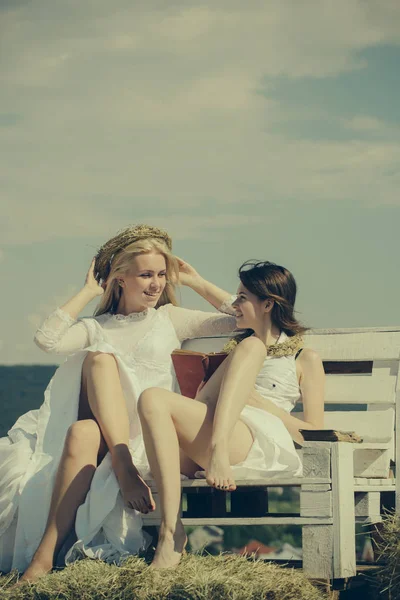 İki kız saman bankta kitap okuma