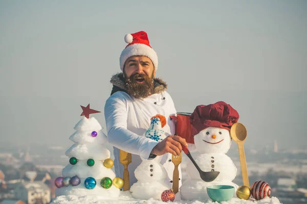 Glücklicher Mann mit Weihnachtsmannmütze, der an einem Wintertag Suppe löffelt — Stockfoto