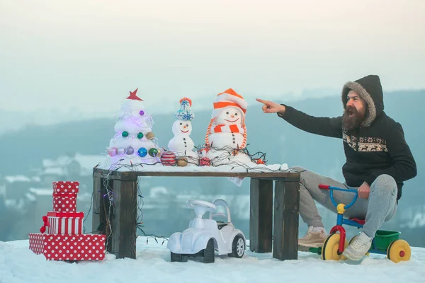 Mann zeigt mit Finger und fährt Dreirad auf Schnee — Stockfoto