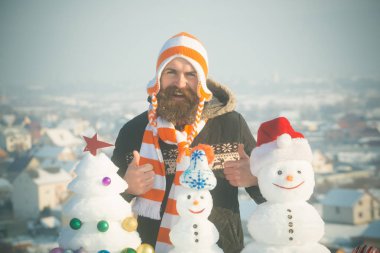 Şapkayla kış gününde gülümseyen hipster