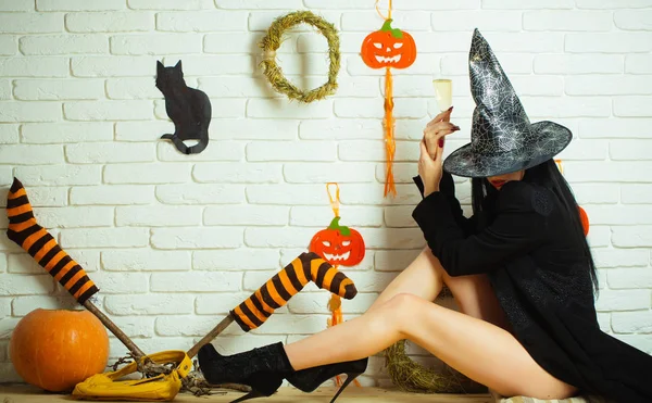 Halloween ragazza con zucche, calze a righe, gatto nero sul muro — Foto Stock