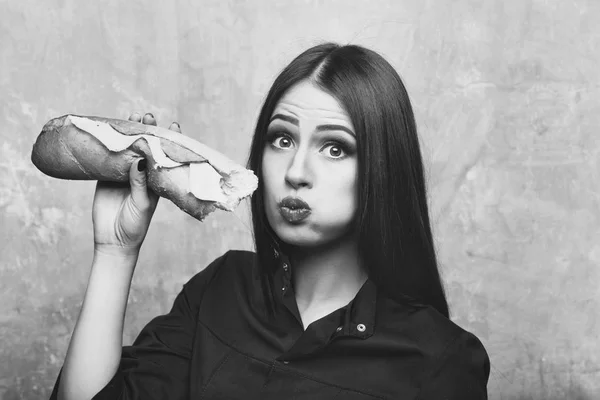 Sexy pretty brunette surprised woman eats big sandwich or burger — Stock Photo, Image