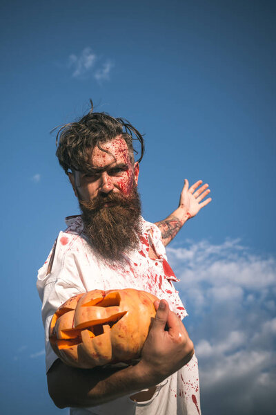 Halloween hipster in bloody torn tshirt with jack o lantern