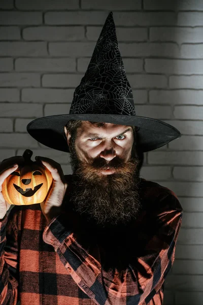 Halloween uomo in cappello da strega con lunga barba che tiene la zucca — Foto Stock