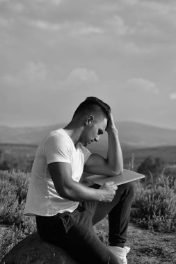 Dizüstü bilgisayar açık ile dalgın kaslı adam