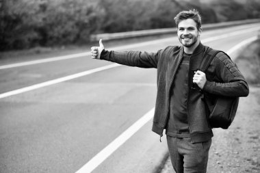 Genç adam otostop çekiyor.