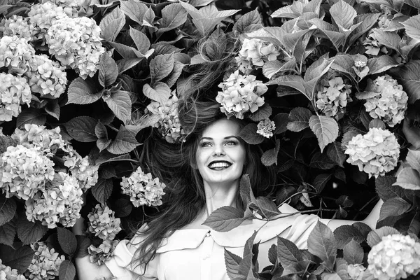 Bella ragazza sorridente in fiori ortensia — Foto Stock