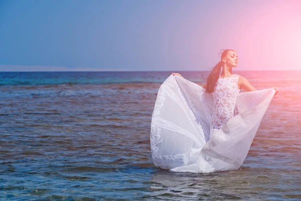 Sposa nella soleggiata giornata estiva sull'acqua blu — Foto Stock