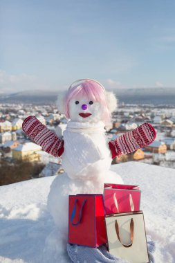 Pembe peruk ve mittens hediye paketi ile kardan adam.