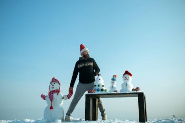 Adam ve mavi gökyüzü elele kardan adam