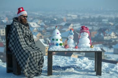 Ekose battaniye kış gününde sandalyede oturan adam