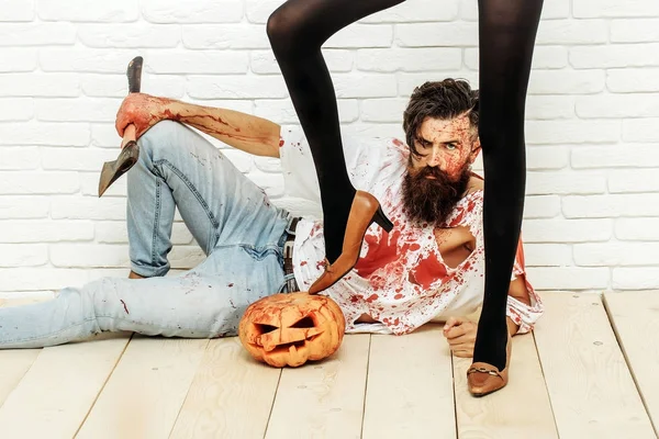 Halloween zombie Brodaty mężczyzna z dyni, topór i kobiece nogi — Zdjęcie stockowe