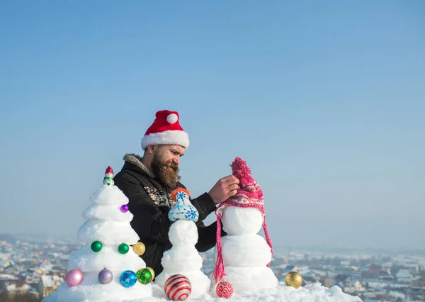 Santa man hoed zetten sneeuwpop — Stockfoto