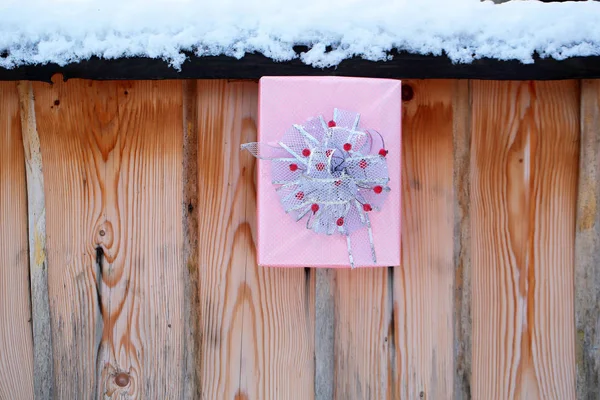 Regalo de Navidad en valla nevada sobre fondo de madera — Foto de Stock