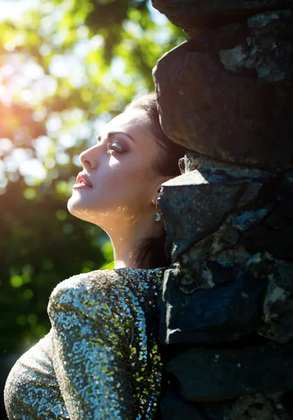 Kvinna poserar på stenmuren på solig dag — Stockfoto