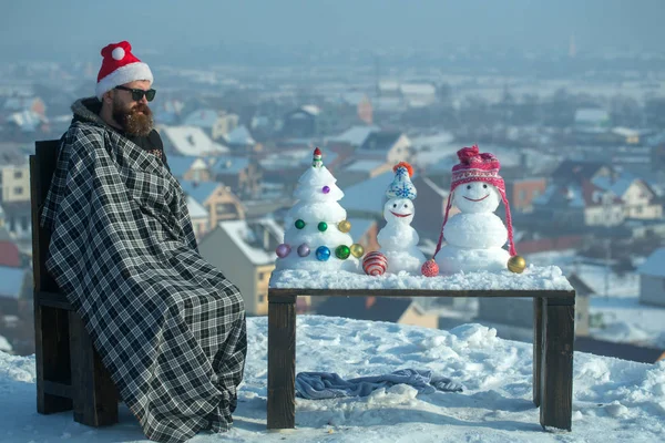 Ekose battaniye kış gününde sandalyede oturan adam