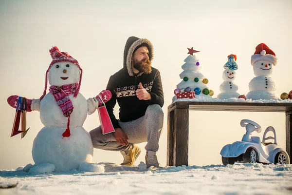 Kardan adam alışveriş torbaları üzerinde beyaz sky ile