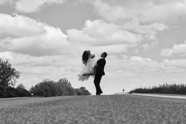 Свадьба счастливая пара танцует на дороге — стоковое фото